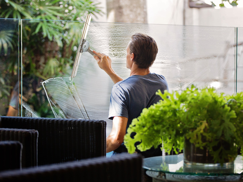 A man is painting the outside of his house.