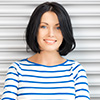 A woman with black hair wearing a striped shirt.